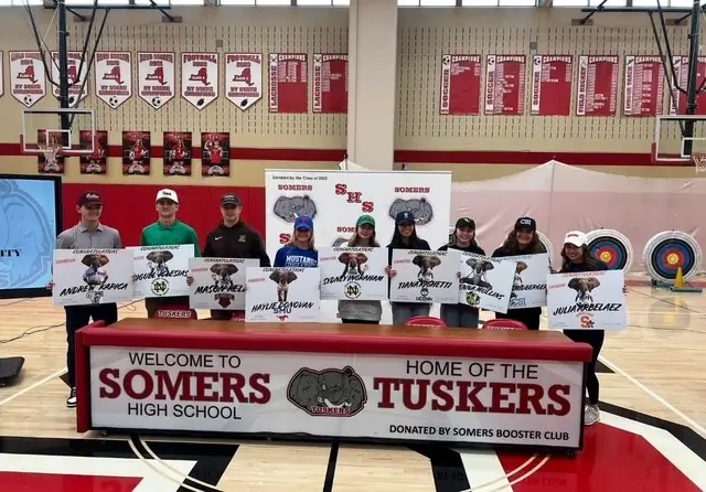 Somers student-athletes at signing day with a table donated by the Booster Club